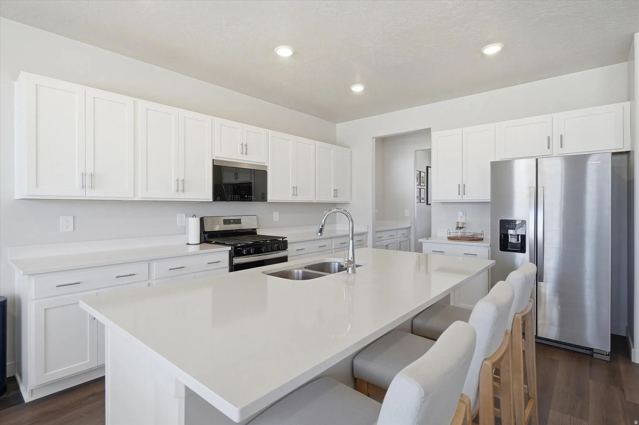 Modern kitchen featuring a large center island with integrated double sink and breakfast bar seating