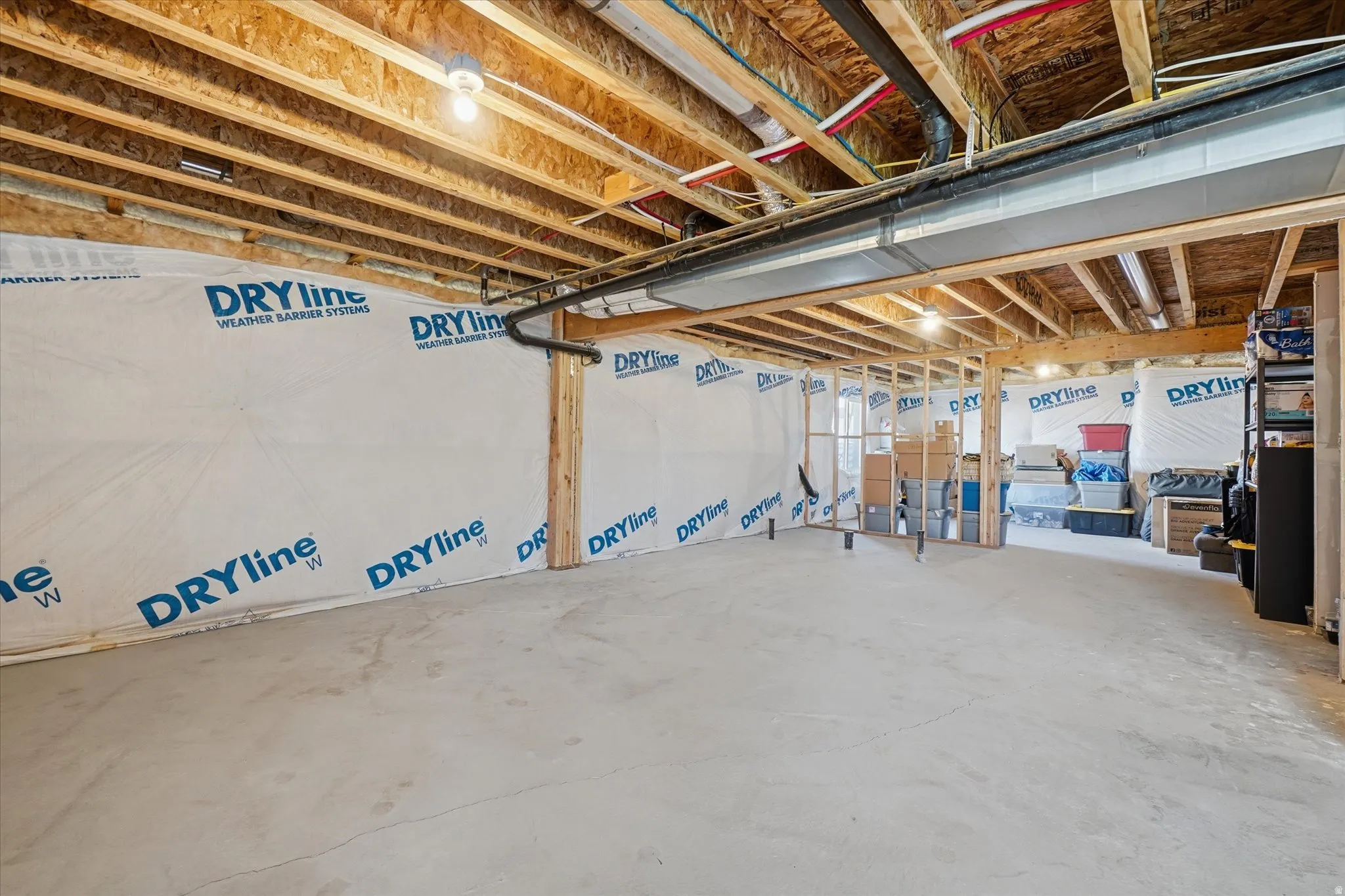Unfinished basement offering expansive concrete flooring and exposed ceiling joists