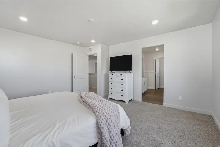Carpeted room with recessed lighting and a neutral wall color
