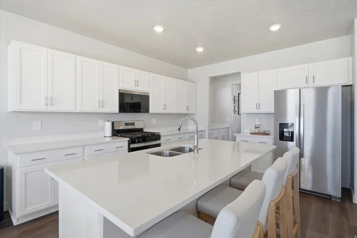Modern kitchen featuring a large center island with integrated double sink and breakfast bar seating