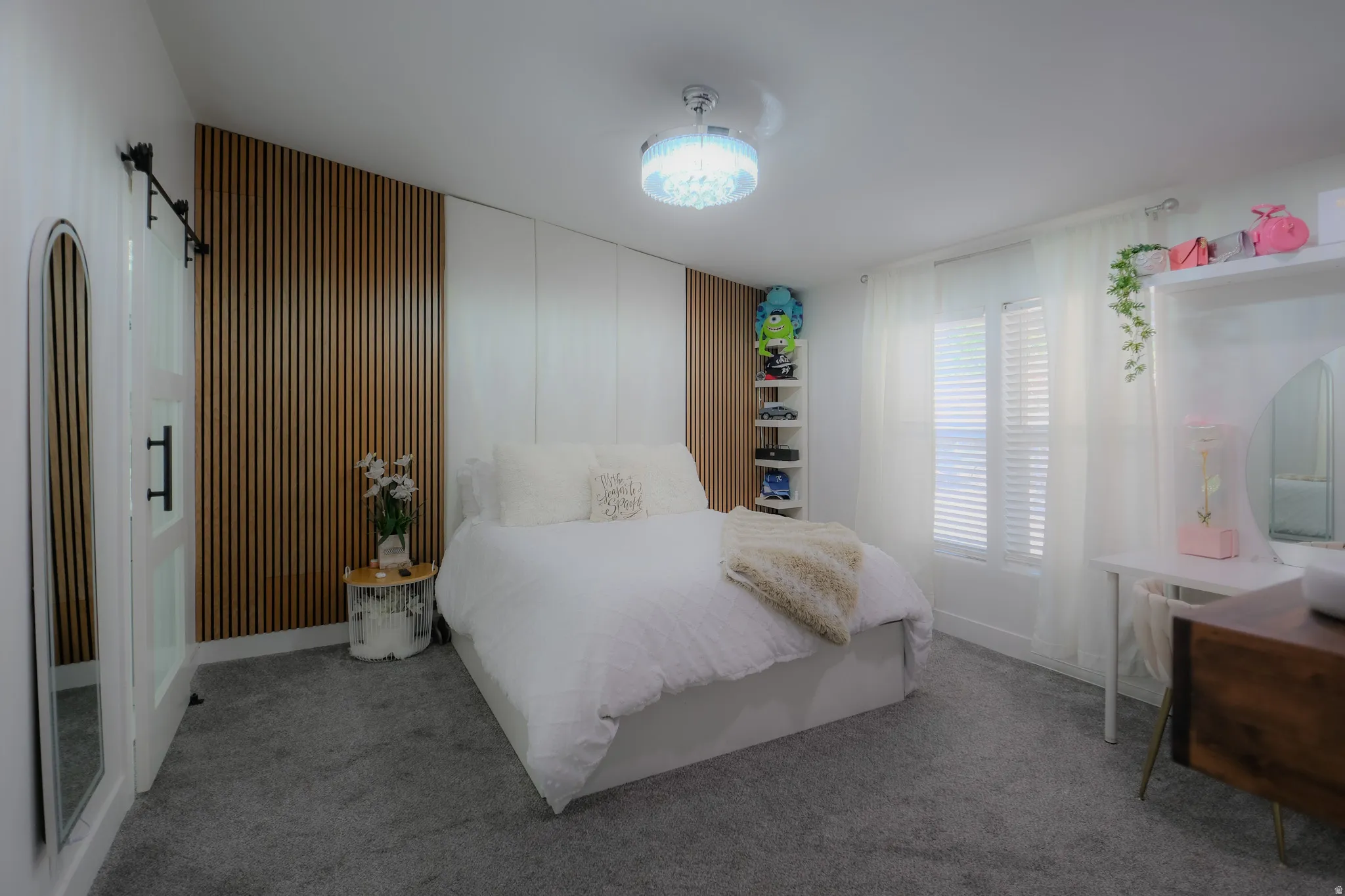 Bedroom featuring a wood-panel accent wall and soft gray carpeting