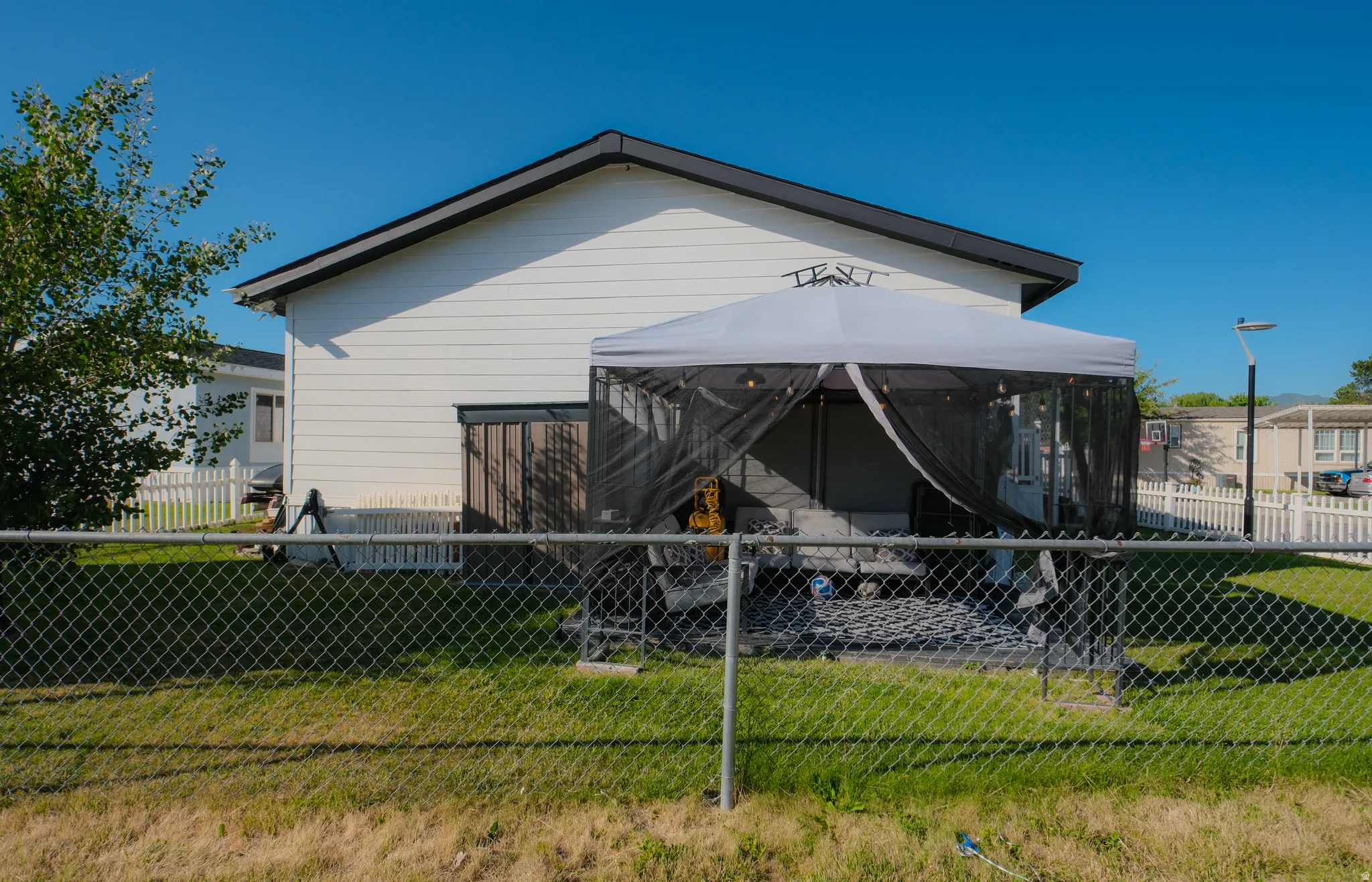 White vinyl siding exterior with a dark trim roofline