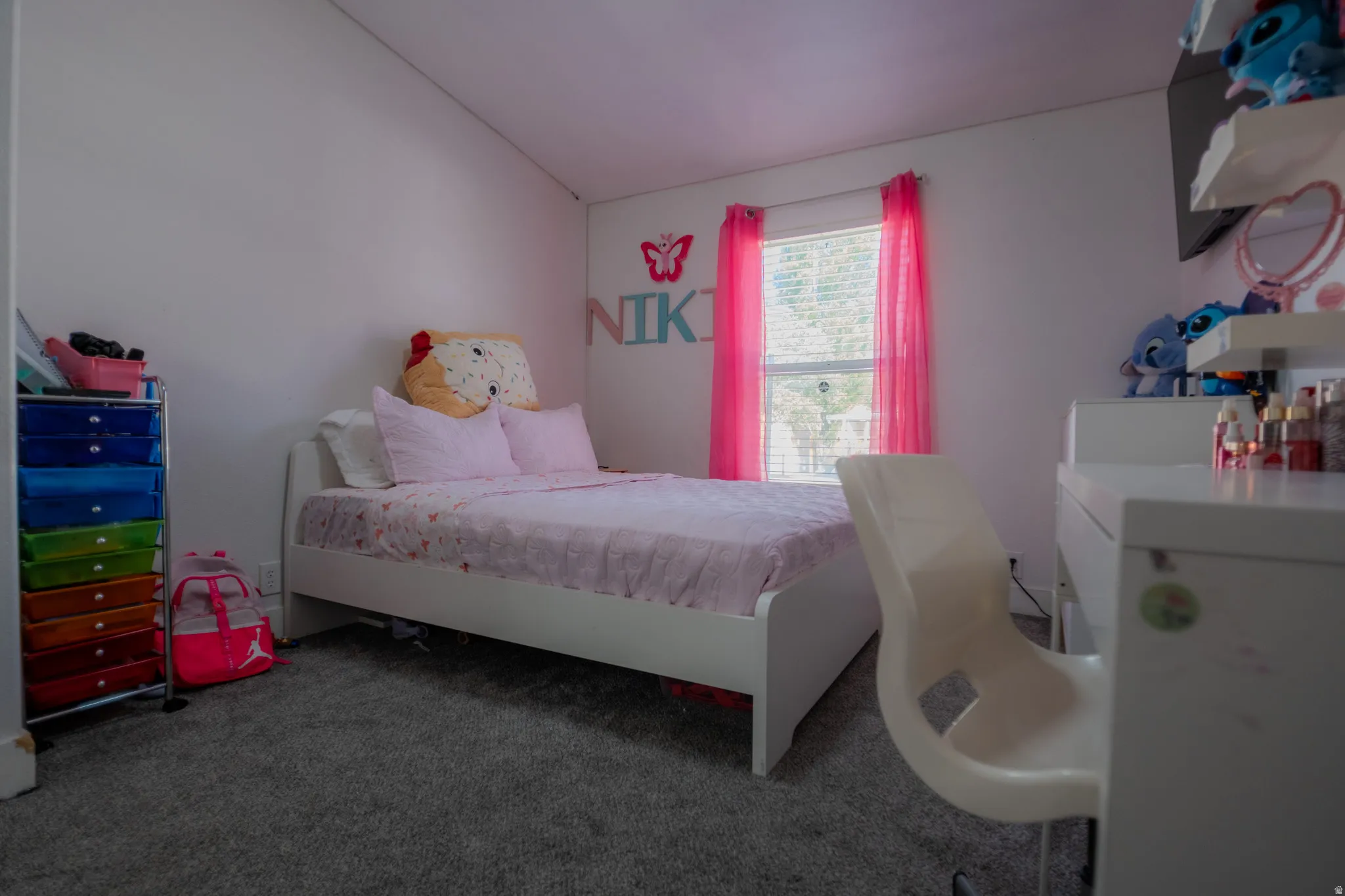 Carpeted room with a double-hung window, white walls, and a sloped ceiling