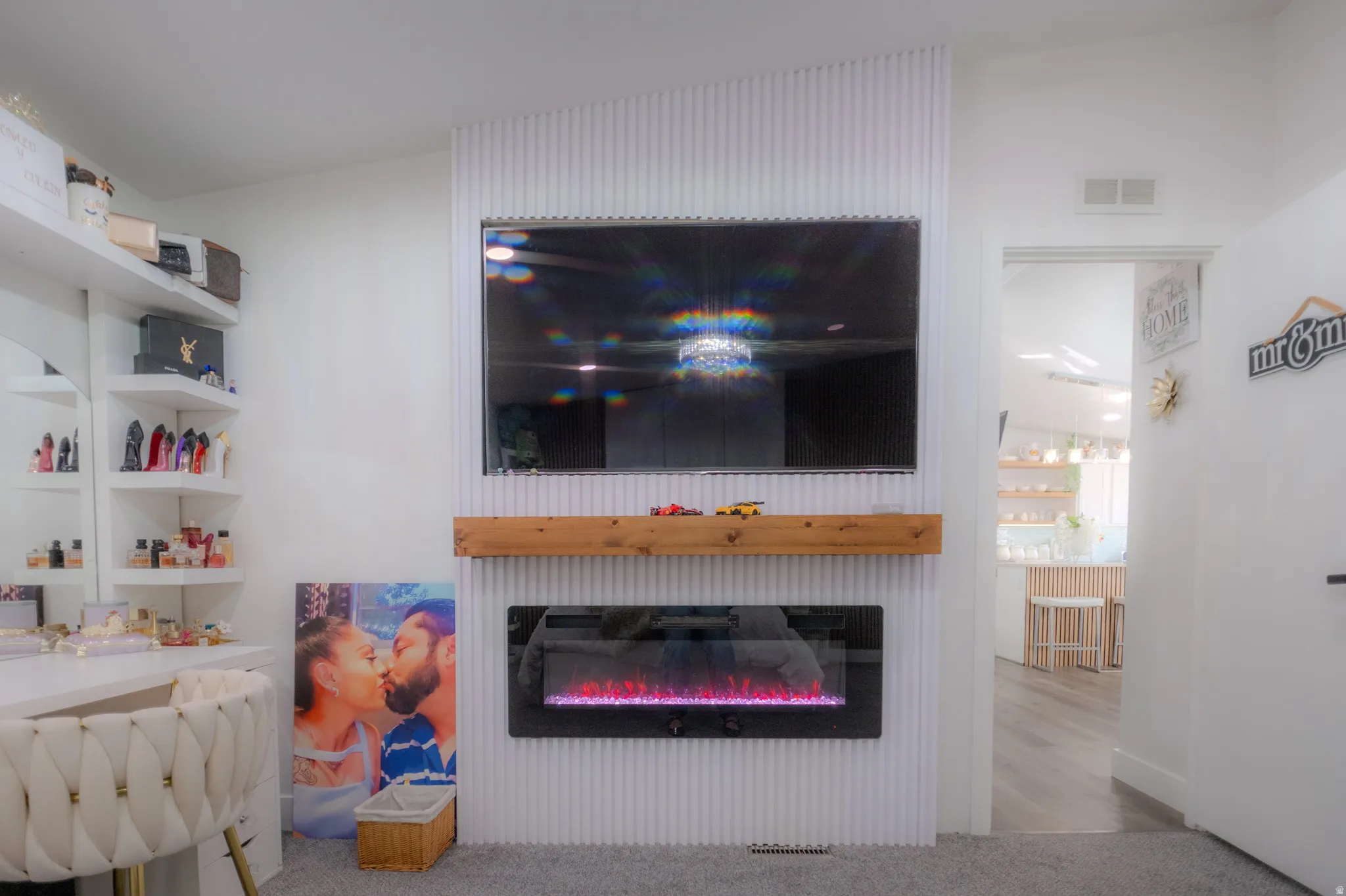 Feature wall with a mounted television above a wood mantel and an electric fireplace