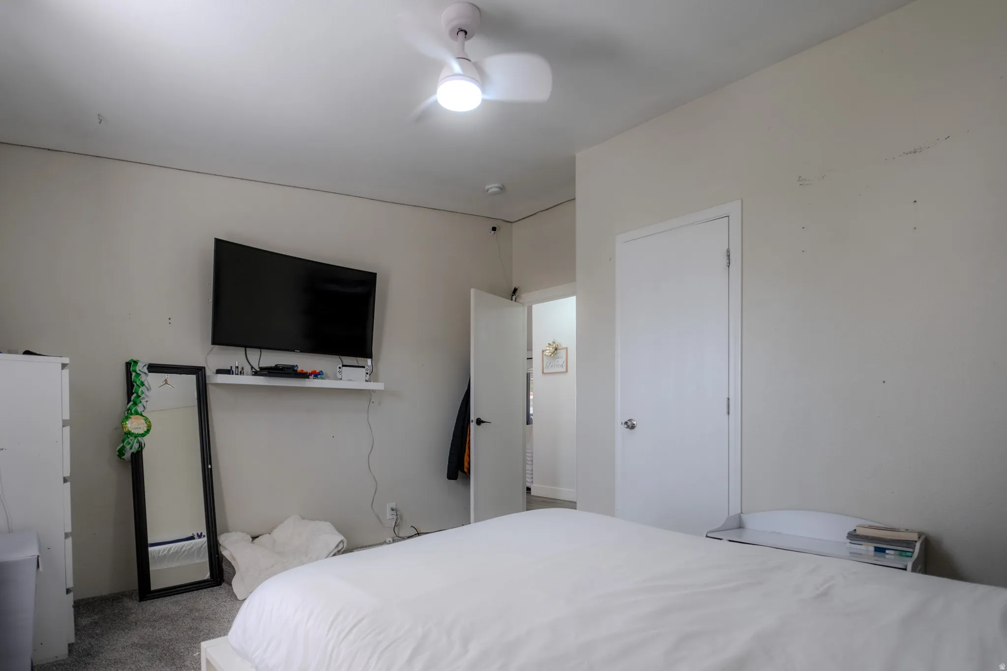 Bedroom with light gray wall paint and light-colored carpeting