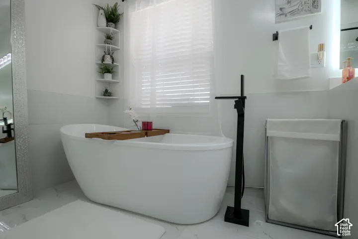 Freestanding soaking tub featuring a matte black floor-mounted faucet