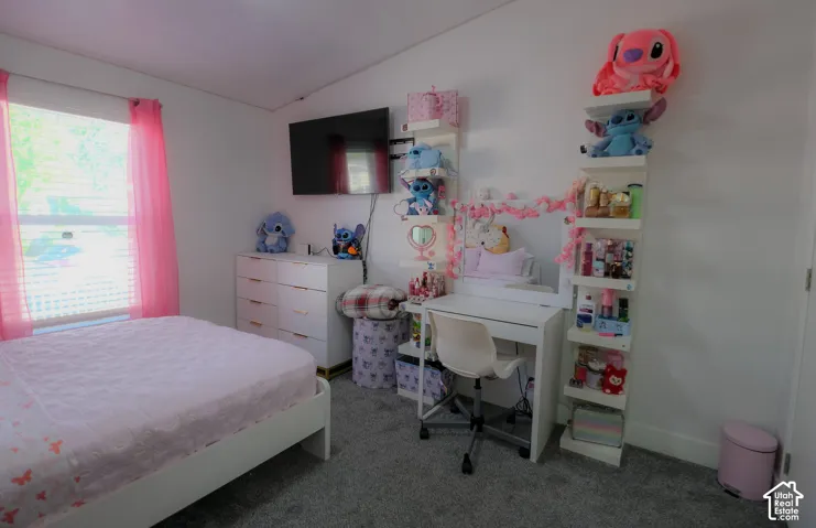 Room featuring light gray carpet flooring, white walls, a window with horizontal blinds, and a built-in wall-mounted television