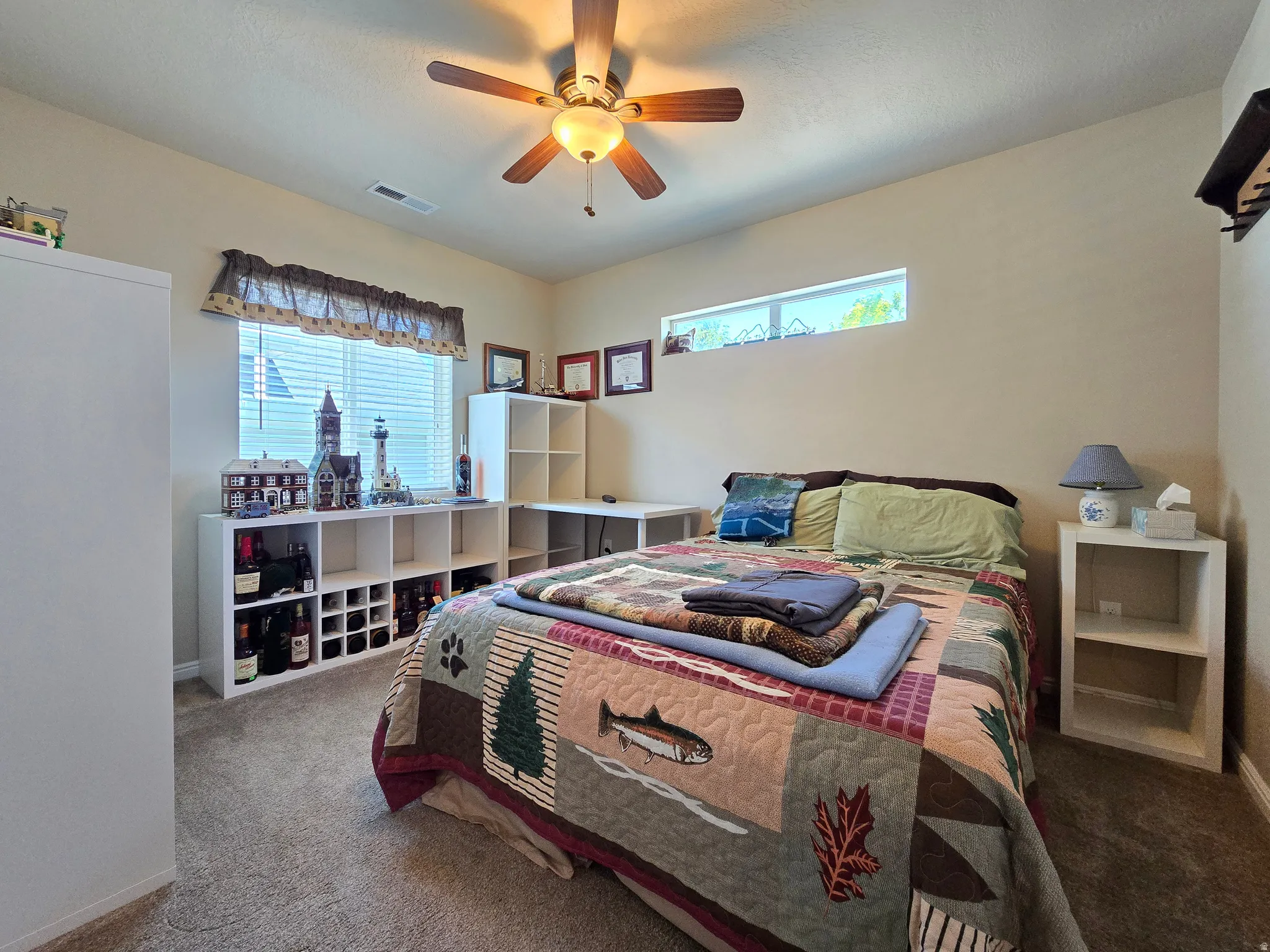 Carpeted room featuring a ceiling fan with integrated lighting, a wide window with blinds, and a high horizontal window