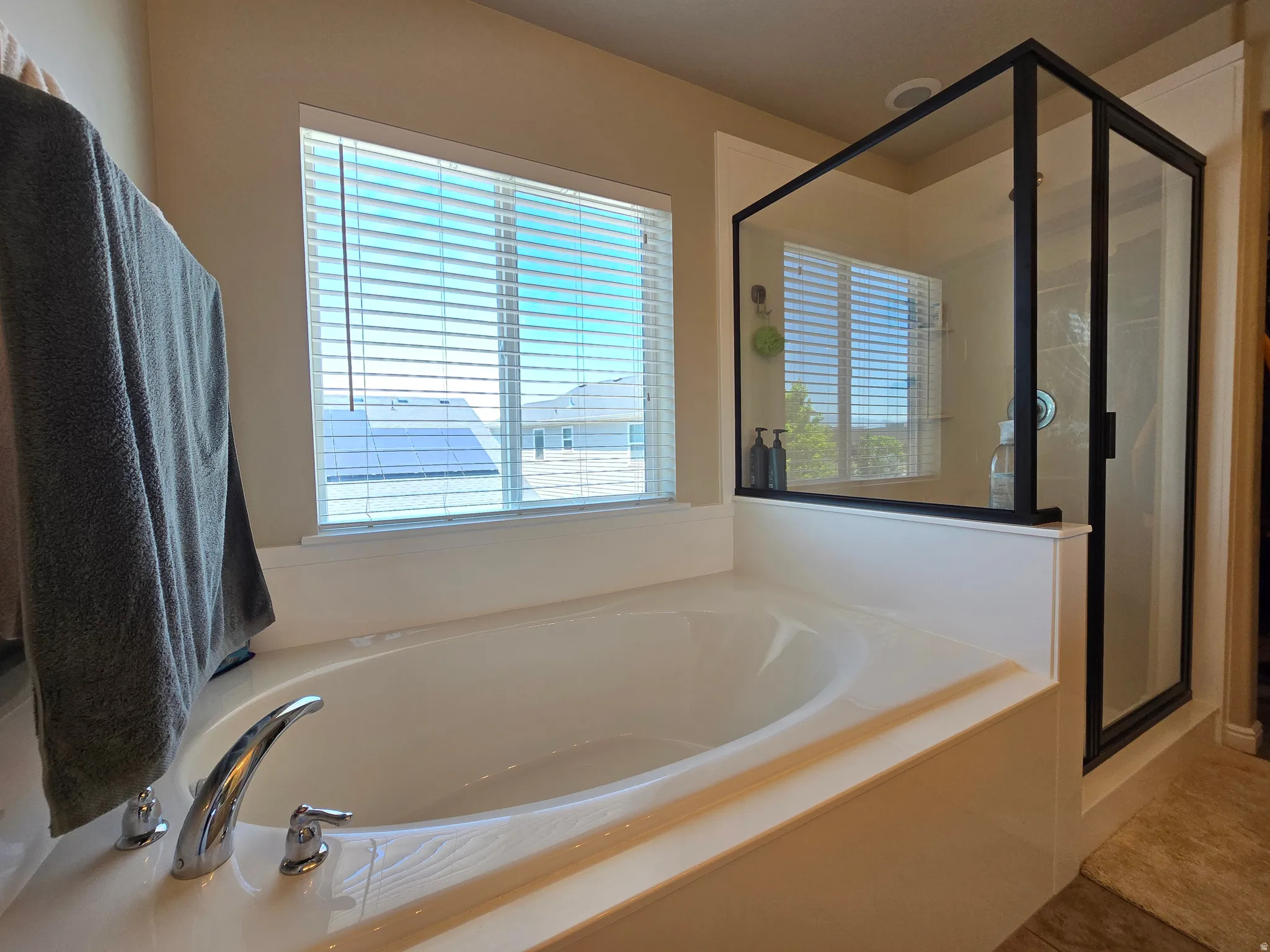 Deep soaking tub with chrome fixtures, integrated into a tiled surround