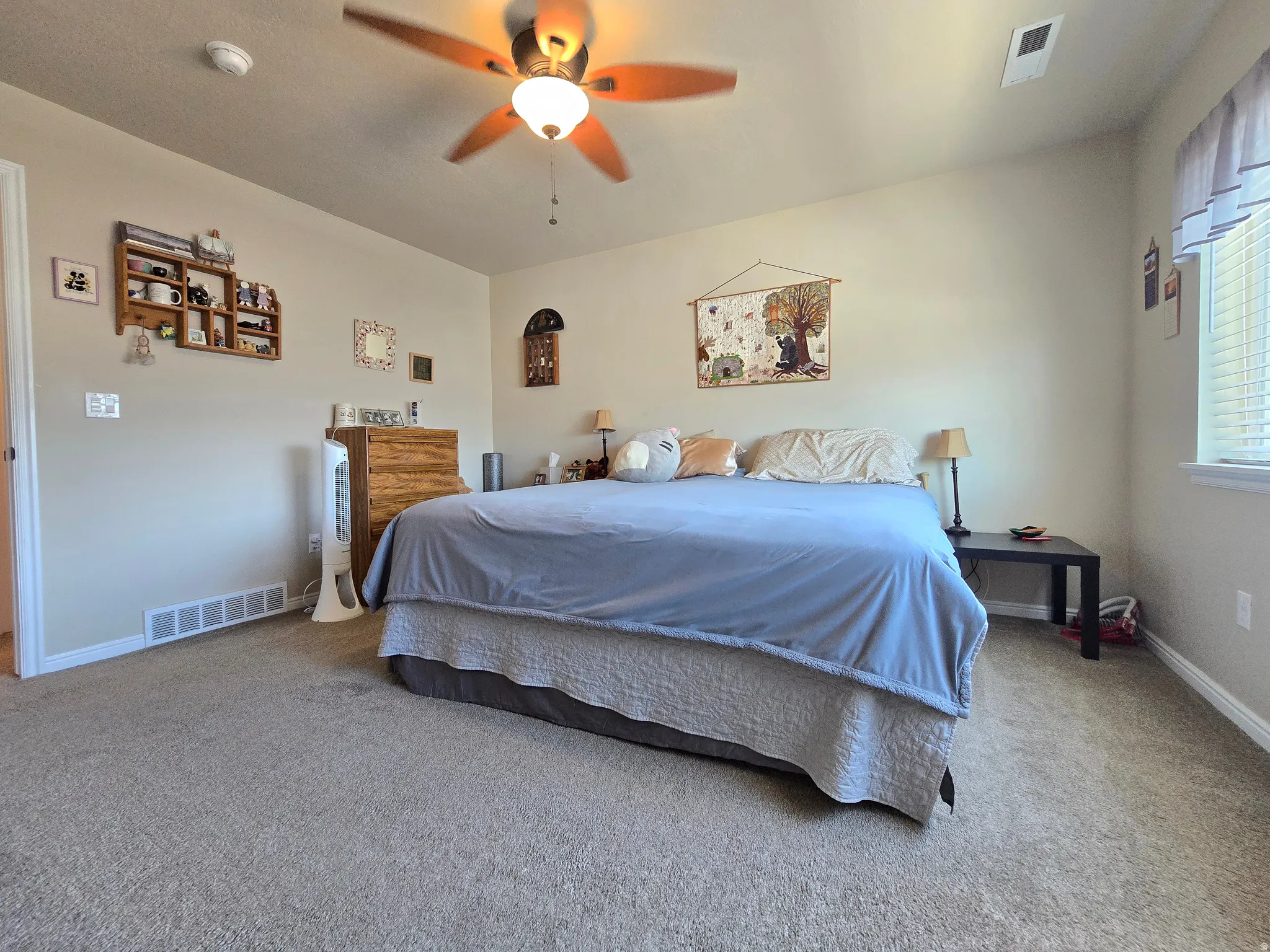 Carpeted room featuring a ceiling fan with integrated lighting, a window with blinds, and white trim