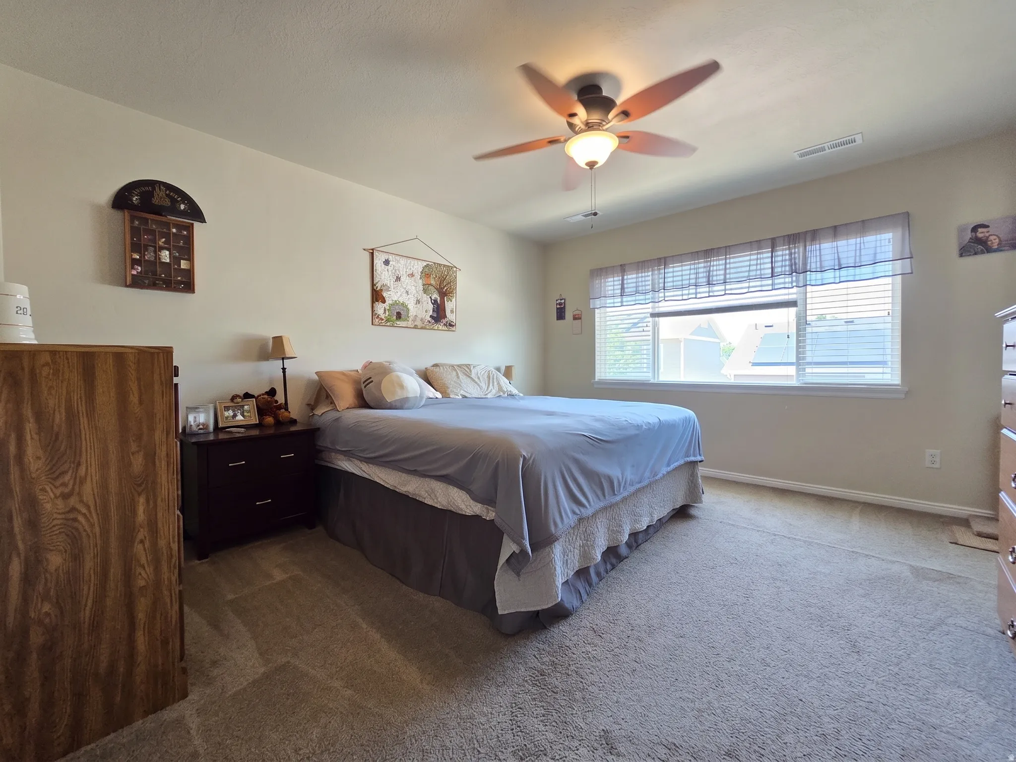 Spacious room featuring neutral carpeting and a ceiling fan with integrated lighting
