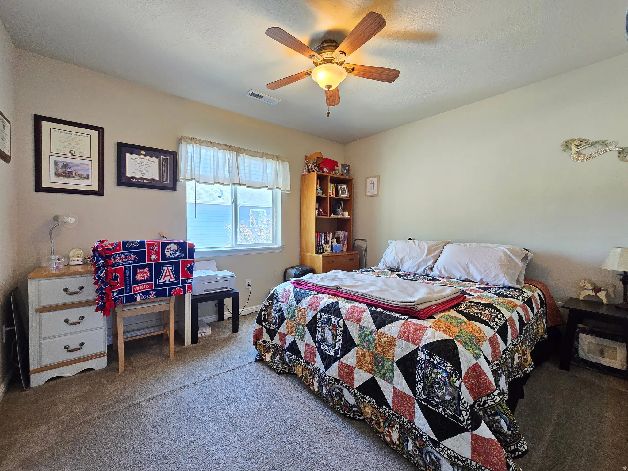 Carpeted room featuring a ceiling fan with light fixture, a window with horizontal blinds, and neutral wall tones