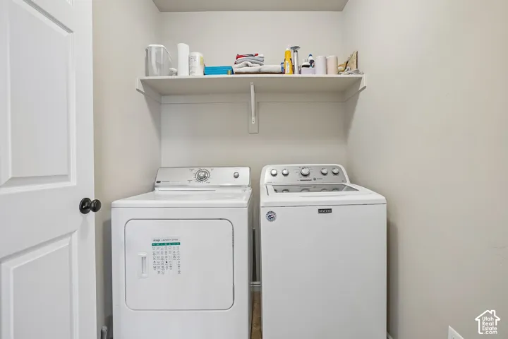 Dedicated laundry area featuring a built-in shelving unit, crisp white walls, and a white paneled door with a matte black knob