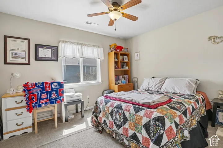 Carpeted room with a ceiling fan, a window, and light-toned walls