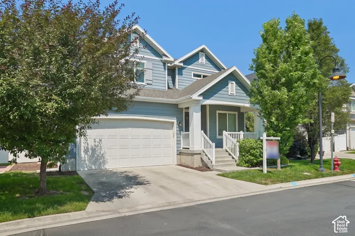 Two-story residence featuring light blue siding with white trim accents and a covered front porch with white railings