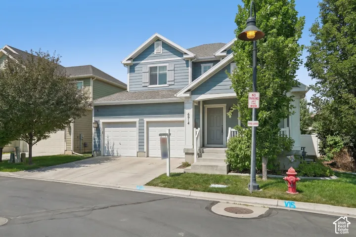 Two-story residence featuring blue siding with white trim, a gabled roofline, and a two-car garage with white doors