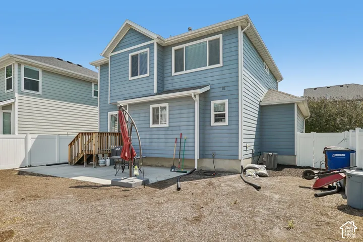 Rear exterior featuring blue horizontal siding, white trim, and multiple windows