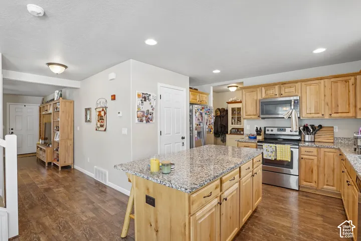 Kitchen featuring wood-finish flooring, recessed lighting, and a center island with a granite-style countertop
