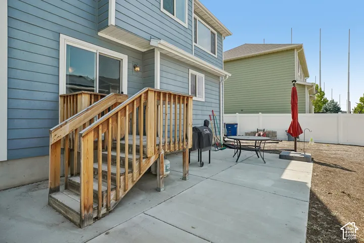 Rear exterior featuring light blue horizontal siding and a ground-level concrete patio