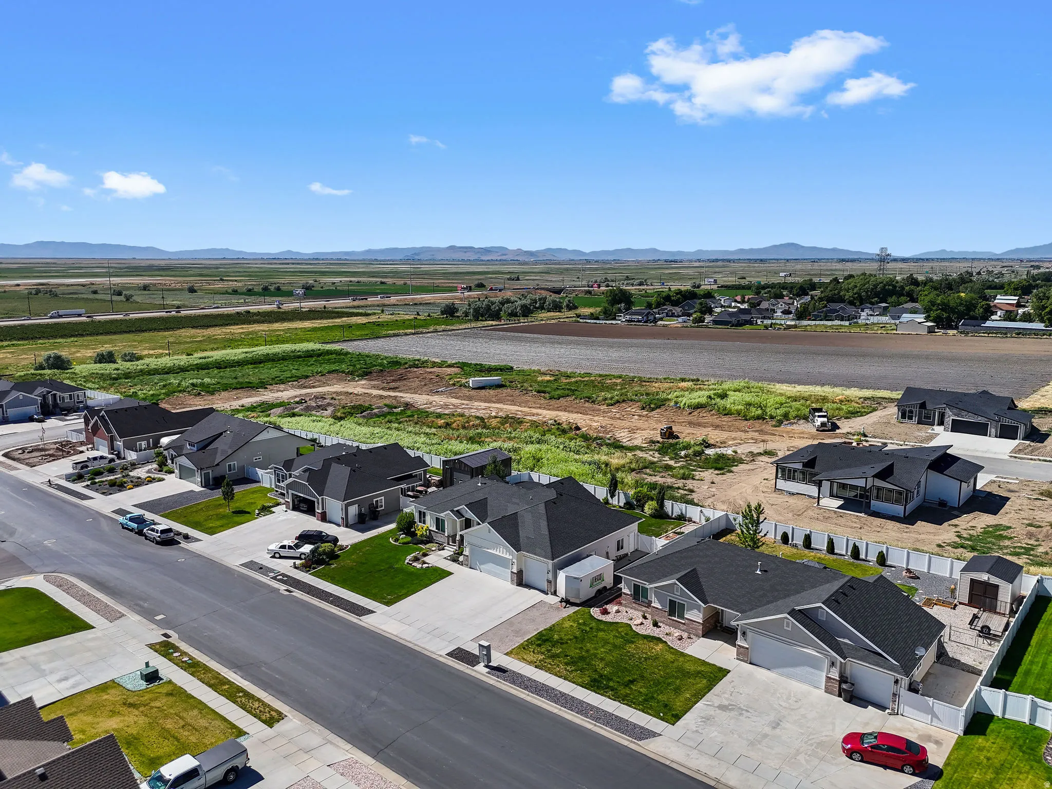 Aerial perspective showcasing a residential street with homes featuring concrete driveways and attached garages
