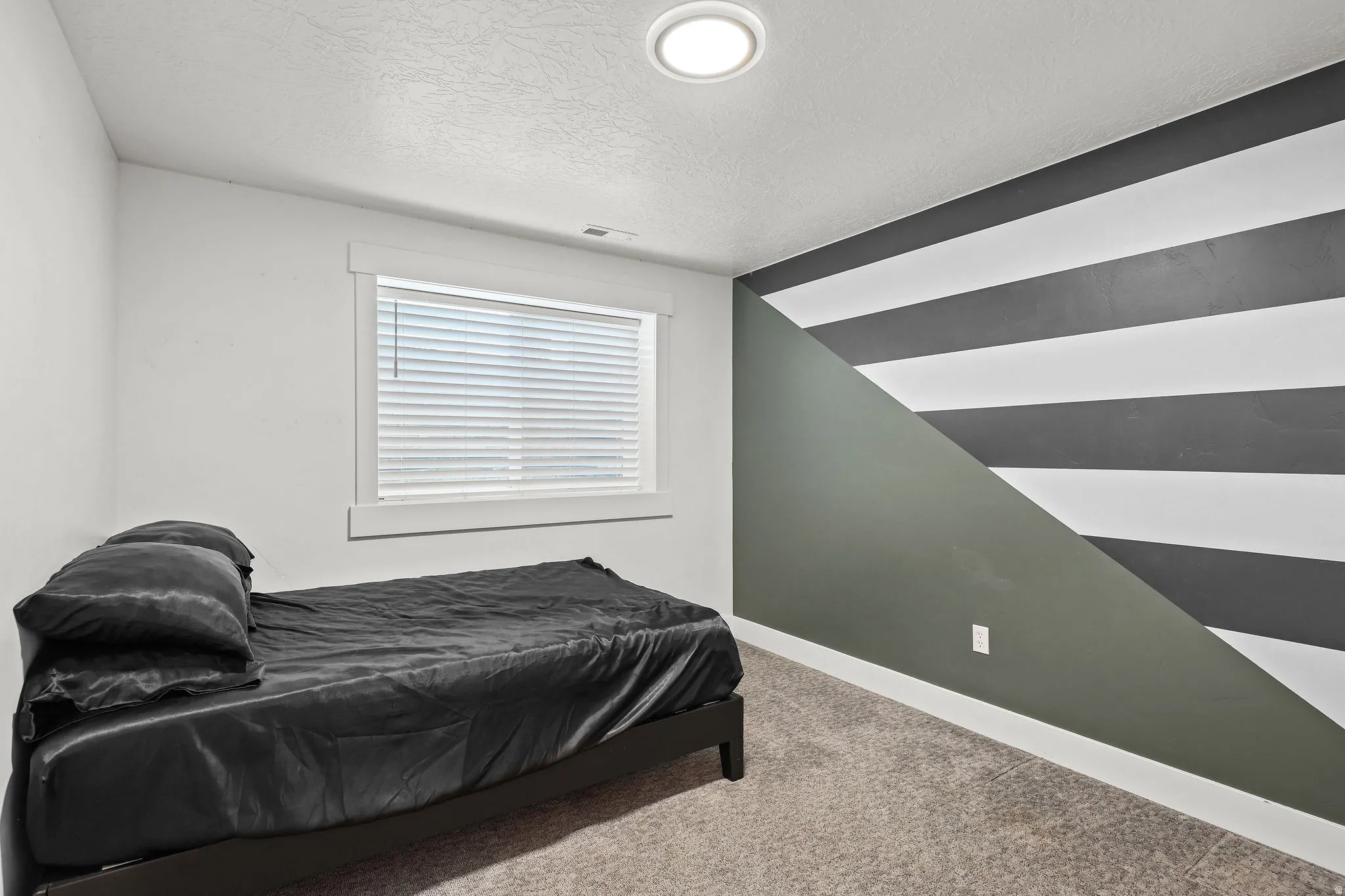 Recessed ceiling lighting illuminates a room featuring carpet flooring and white walls