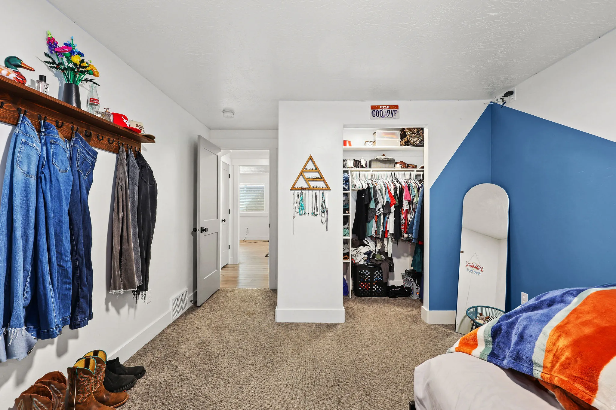 Carpeted interior space featuring white walls with a blue accent wall