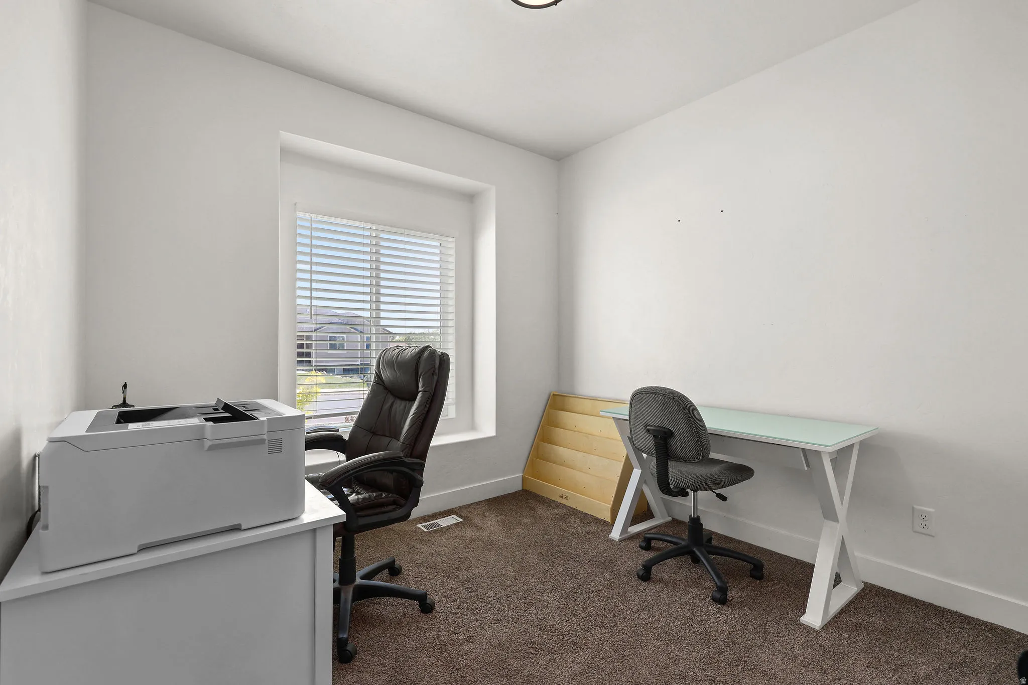 White-painted room featuring a window with blinds, recessed ceiling light, and brown carpet