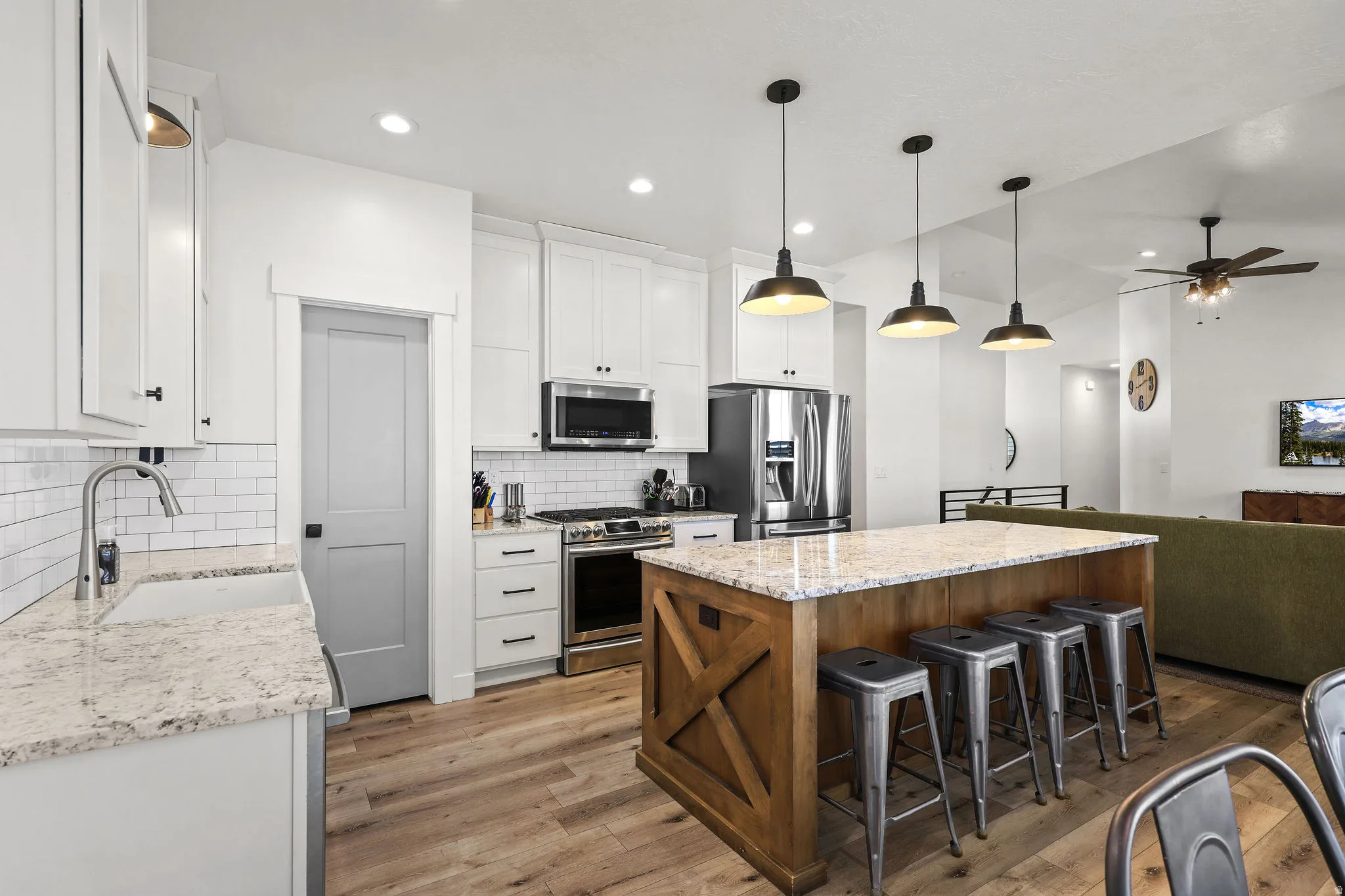 Kitchen featuring a large central island with seating, white cabinetry, and stainless steel appliances
