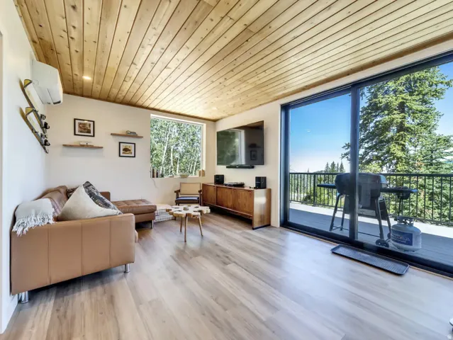 Spacious living area featuring wood-finish flooring and a wood-paneled ceiling