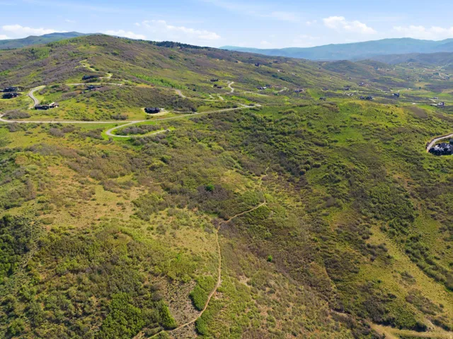 Expansive mountainous terrain featuring scattered residential structures
