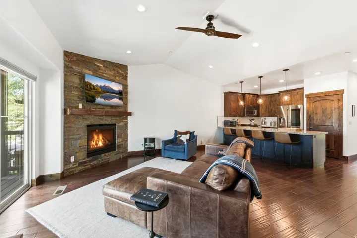 Open-concept living space featuring wood-finish flooring and a vaulted ceiling