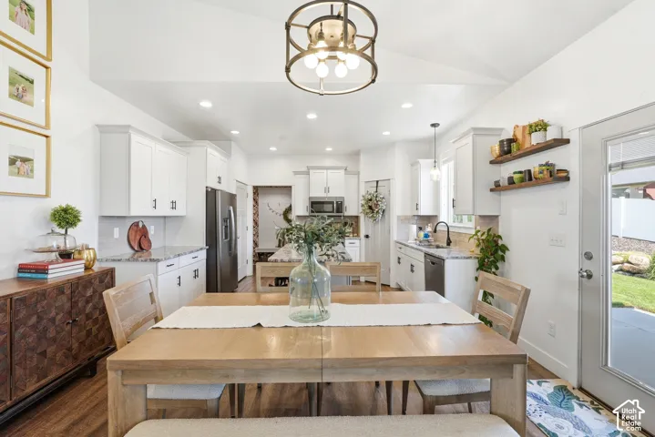 Spacious open-concept kitchen and dining area featuring vaulted ceilings, recessed lighting, and wood-finish flooring