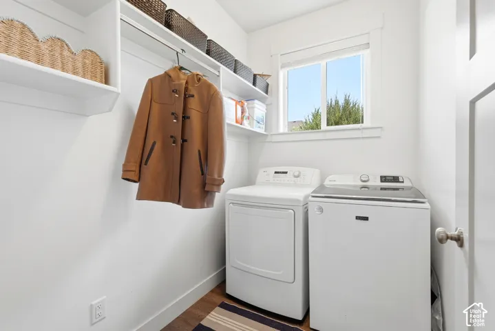 Bright utility space featuring a window, wood-finish flooring, white baseboards, a built-in hanging rod, and wall-mounted shelving