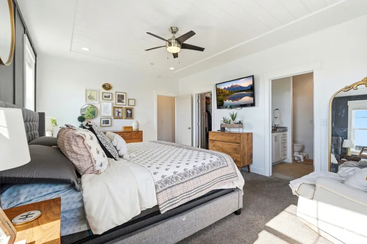 Bedroom featuring a tray ceiling with shiplap detailing, a ceiling fan with integrated lighting, recessed lighting, carpet flooring, and a sliding door