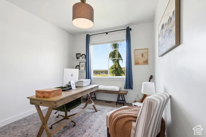 Bright room featuring a drum pendant light, a large window with white trim, and light-colored walls