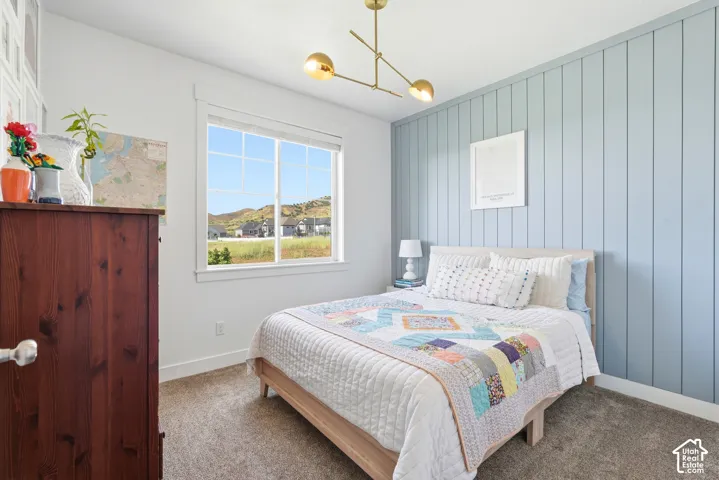 Bedroom featuring a light blue vertical plank accent wall and a window with white trim