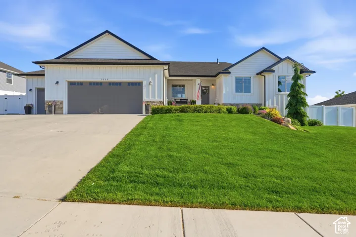 Contemporary ranch-style exterior featuring white vertical siding and dark trim accents