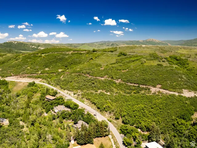 Expansive green hillsides and distant mountains under a clear blue sky
