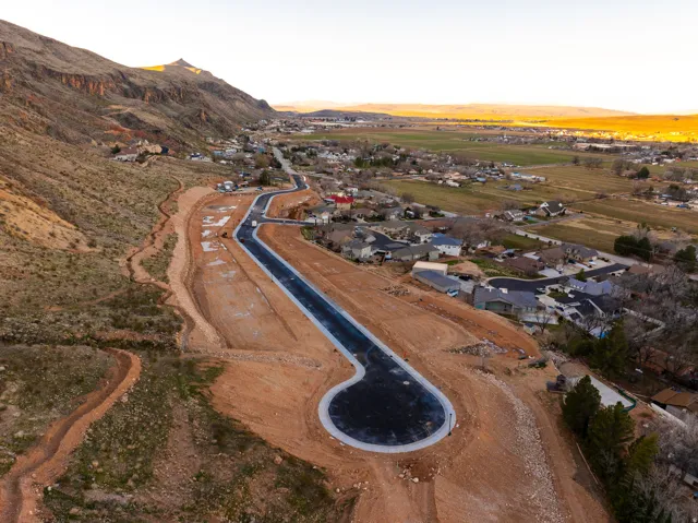New development featuring paved roads with concrete curbing, graded lots, and mountain scenery