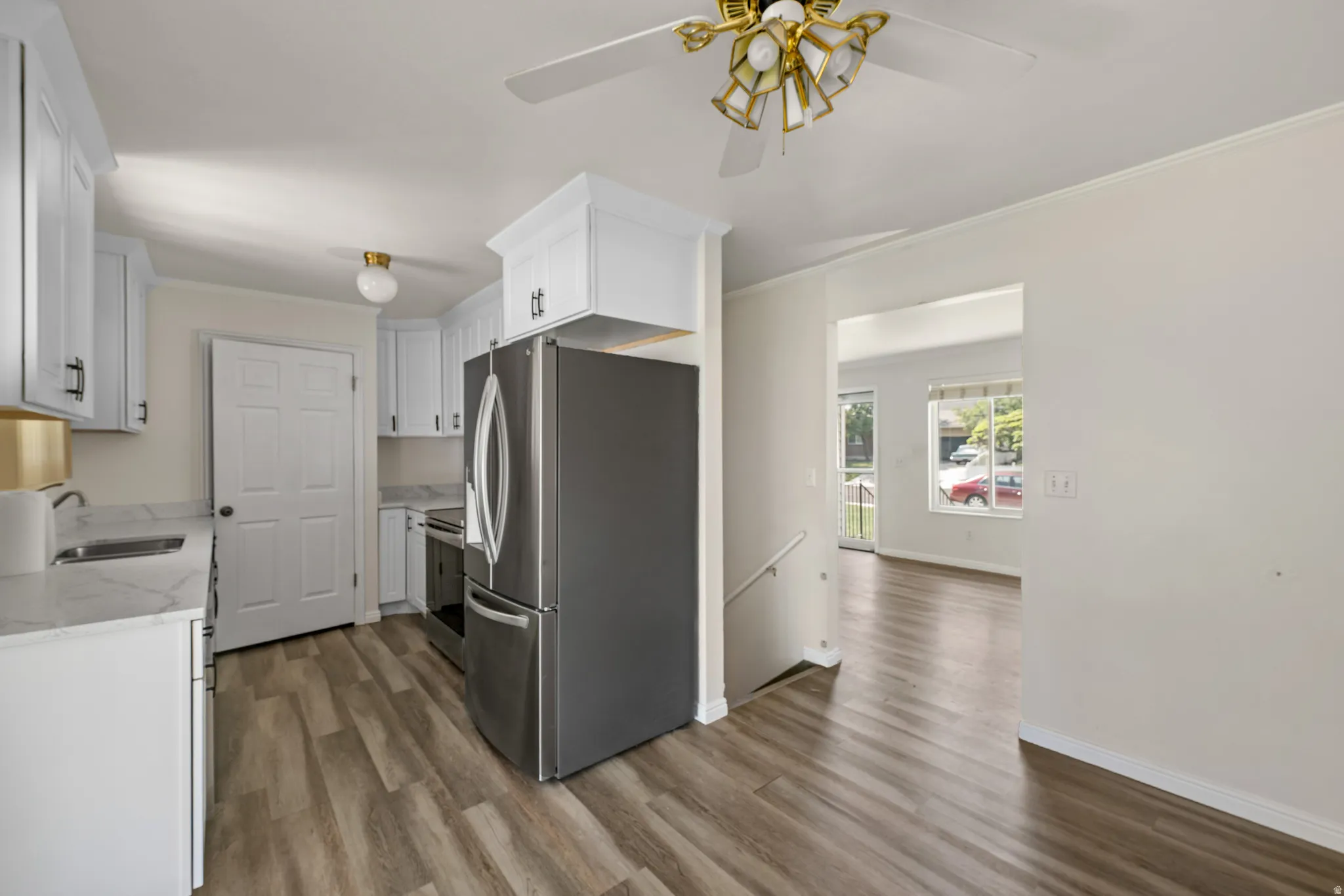 Kitchen featuring white cabinetry, light-toned countertops, and wood-finish flooring