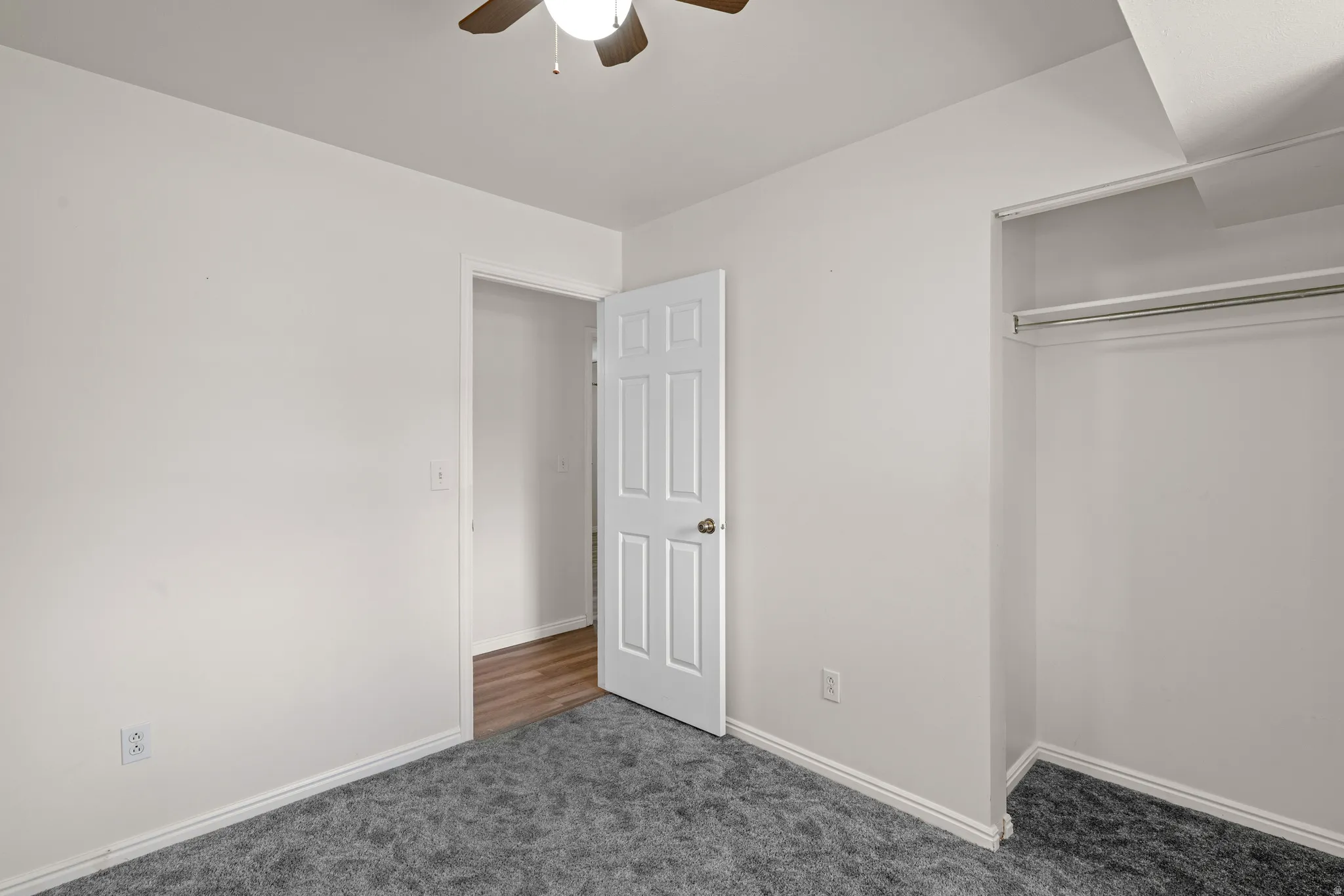 Room featuring neutral wall tones, grey textured carpeting, and white trim