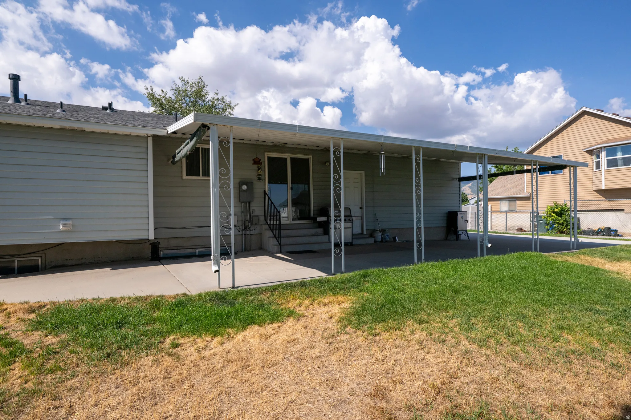 Covered patio with an extended concrete pad and a sliding glass door entry