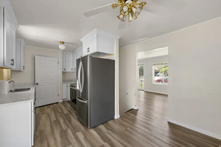 Kitchen featuring white cabinetry, light-toned countertops, and wood-finish flooring