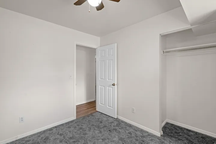 Room featuring neutral wall tones, grey textured carpeting, and white trim