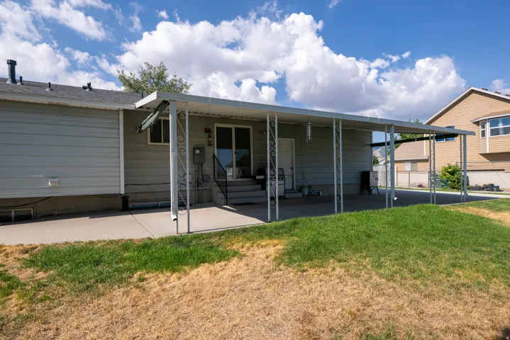 Covered patio with an extended concrete pad and a sliding glass door entry