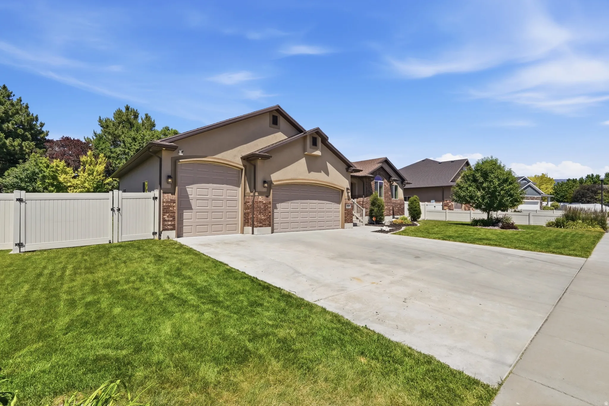 Sienna-toned stucco exterior with stone accents and twin arched garage doors