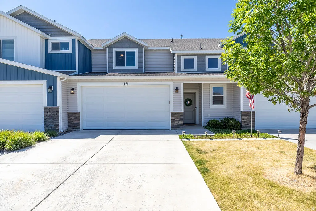 Two-story townhome with a light gray siding exterior, featuring an attached two-car garage