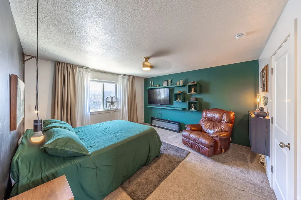 Bedroom featuring carpet flooring, built-in wall shelving, a ceiling fan, and a white interior door