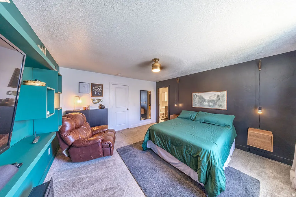 Spacious room featuring a dark accent wall, a ceiling fan with integrated lighting, and a built-in media console with open shelving