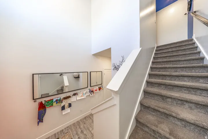 Carpeted staircase with a metal handrail and white baluster